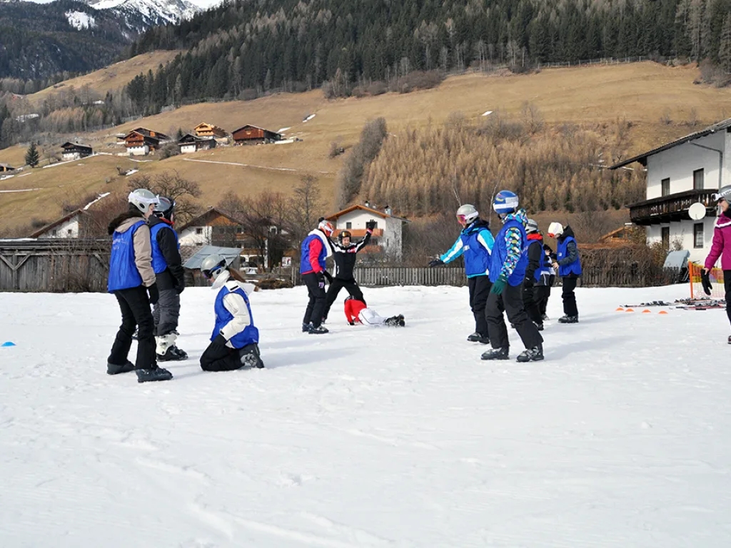Anfängergruppe übt Fallen und Aufstehen im Schnee.